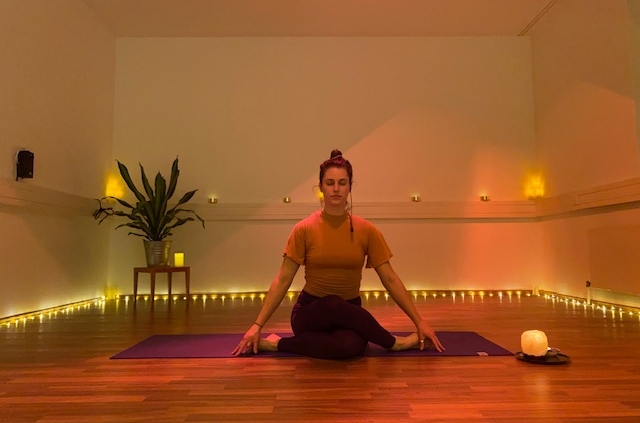 yoga teacher in yoga studio. Candlelight.